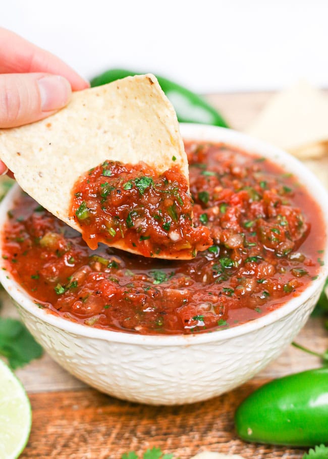 dipping a chip into homemade salsa