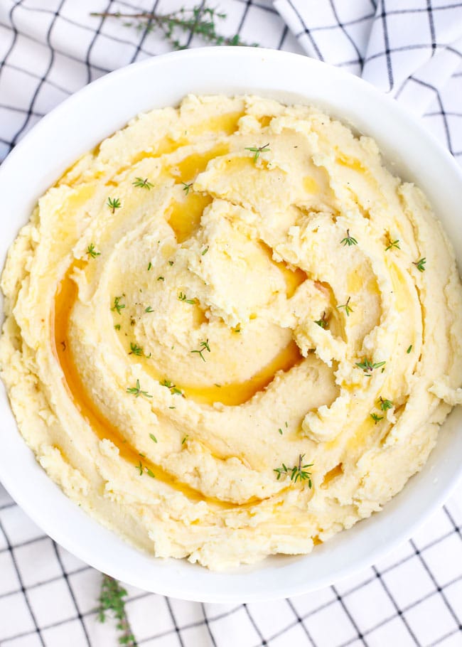 a bowl of brown butter mashed potatoes topped with thyme