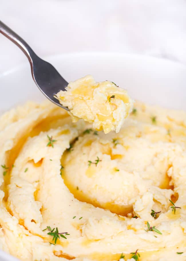 a fork holding mashed potatoes with brown butter