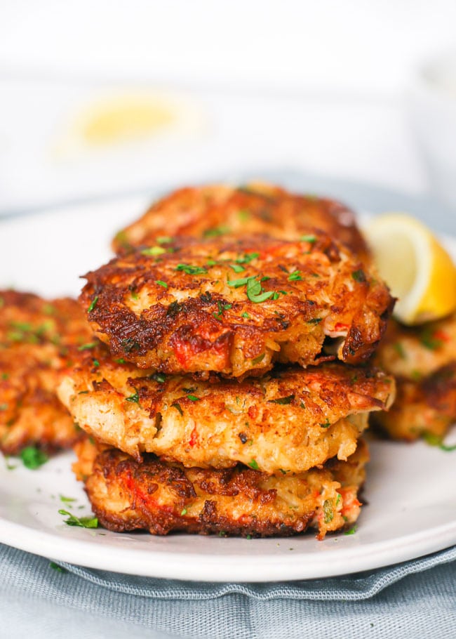 a stack of crab cakes with a lemon wedge
