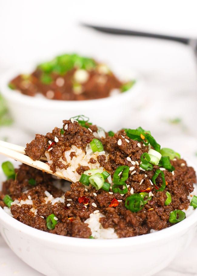 a pair of chopsticks lifting rice and Korean beef