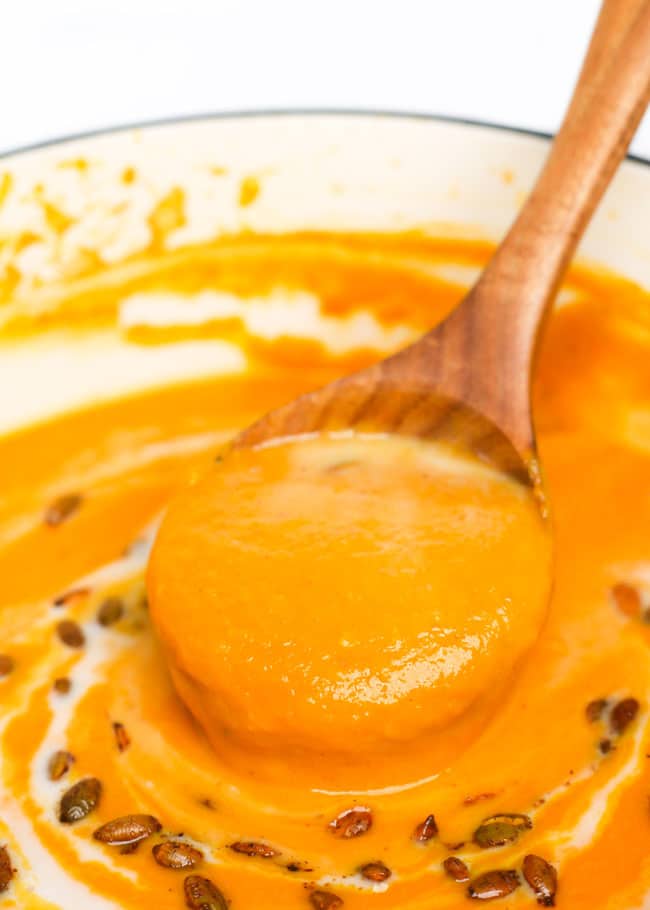a ladle lifting butternut squash carrot soup out of a pot