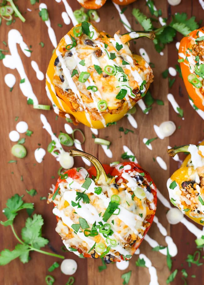 overhead photo of quinoa stuffed peppers drizzled with sour cream