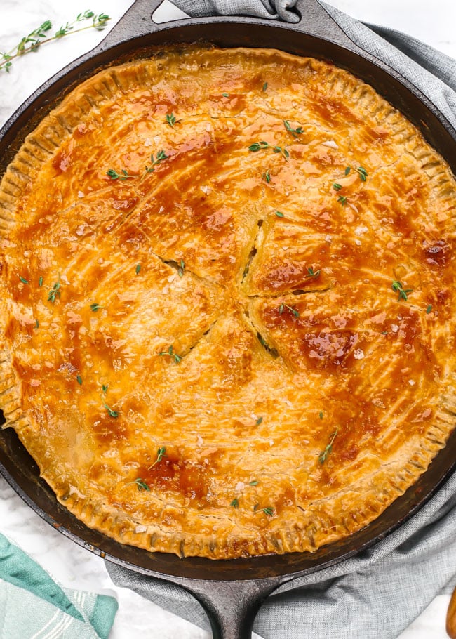 closeup overhead photo of a skillet chicken pot pie garnished with thyme