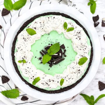 overhead photo of grasshopper pie decorated with whipped cream, oreos, and fresh mint