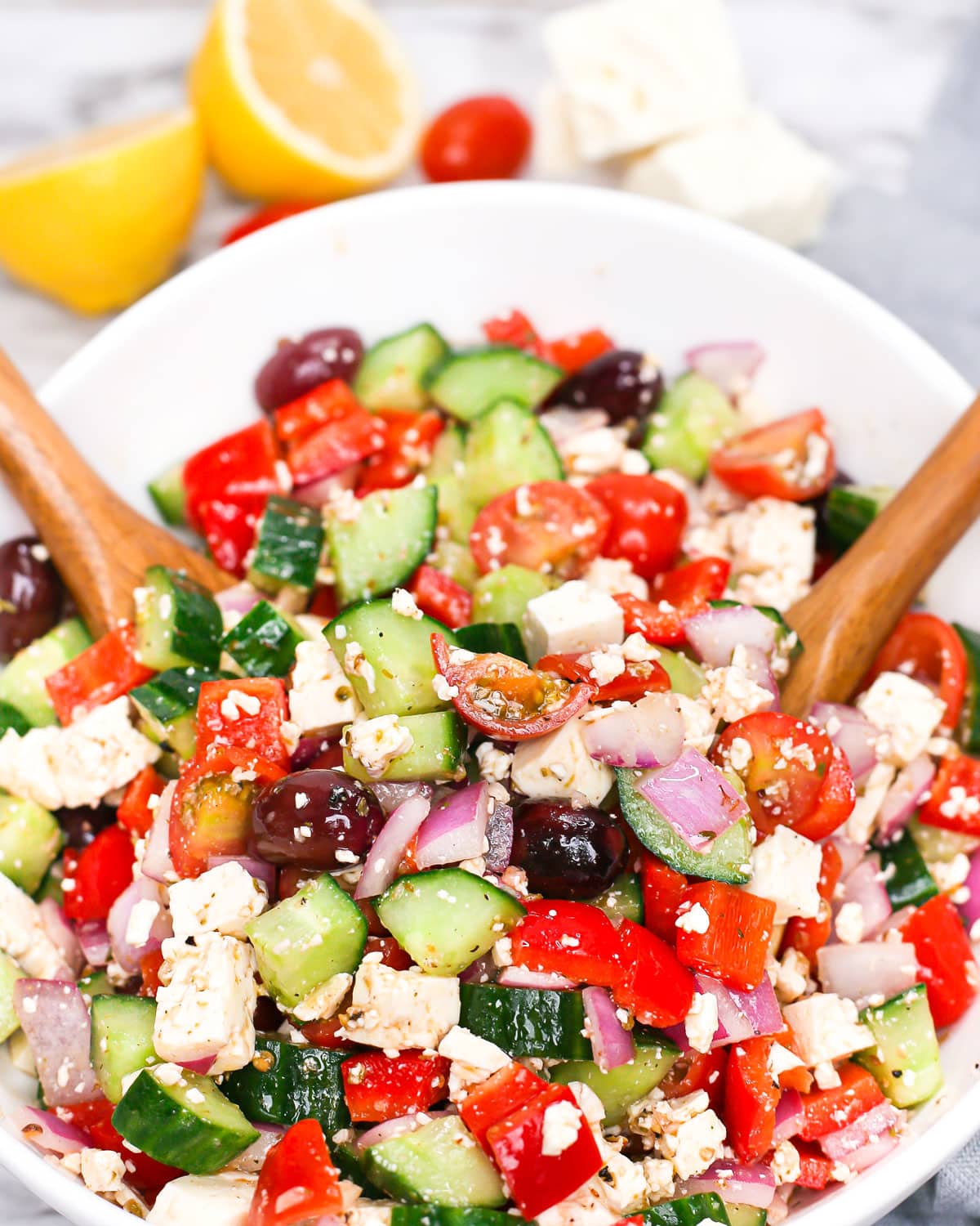salad spoons tossing greek salad