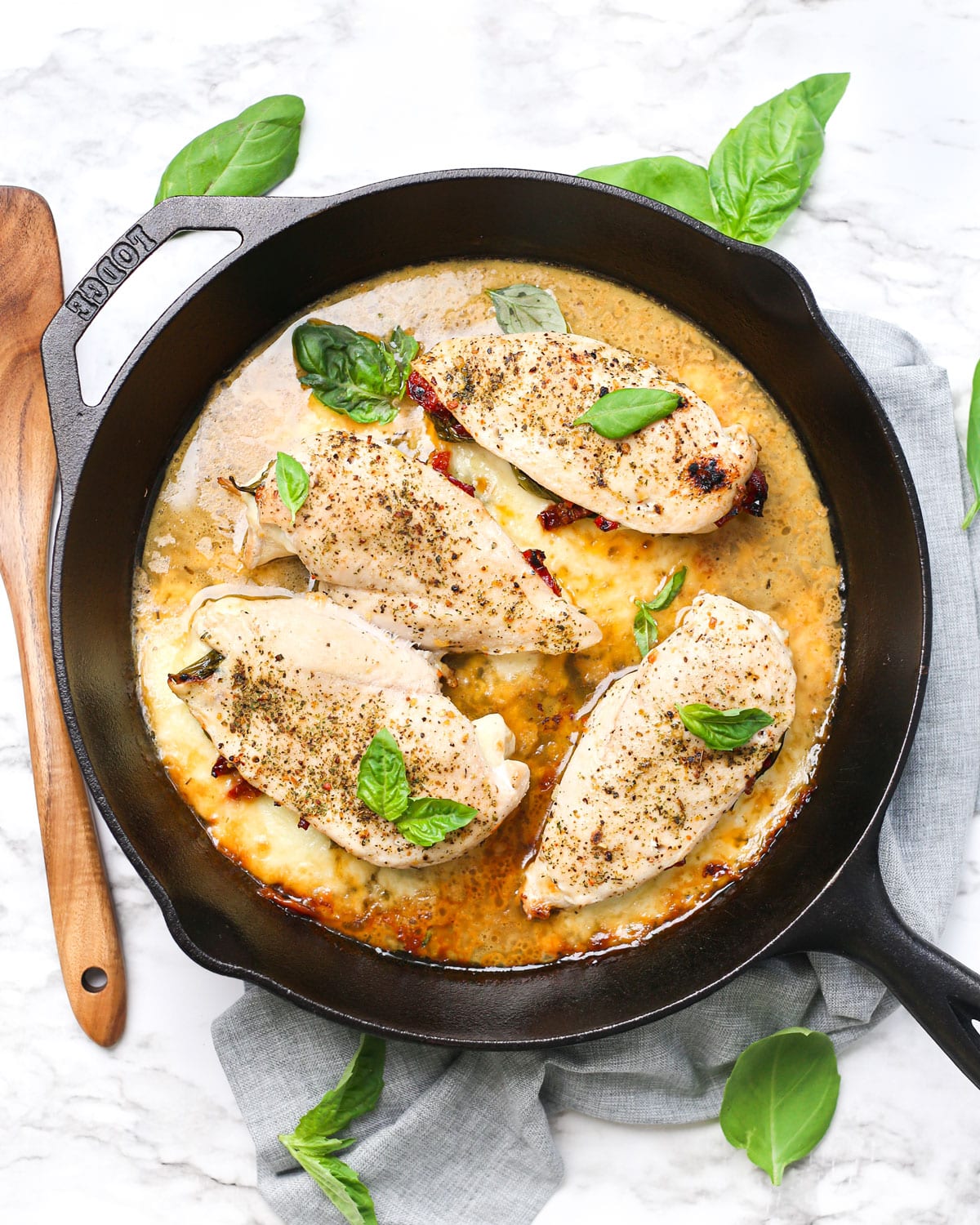 a skillet of tuscan stuffed chicken breasts with sauce